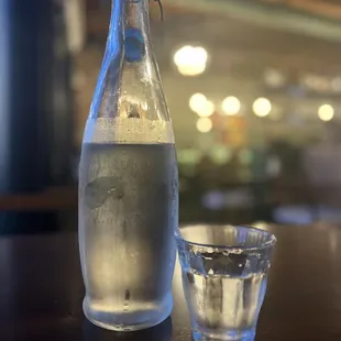 a bottle of water and a shot glass