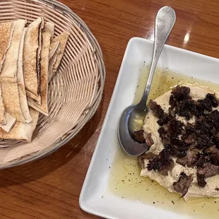 a bowl of hummus and a plate of pita chips