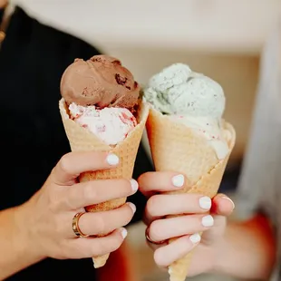two people holding ice cream cones