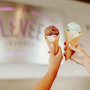 two people holding ice cream cones
