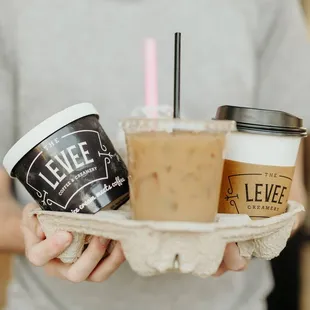 a man holding a tray with two cups of coffee