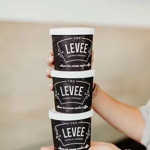 a woman holding three cups