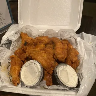 a tray of fried chicken with dipping sauces