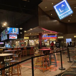 the inside of a restaurant with tables and stools
