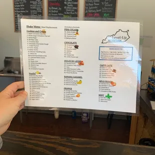 a person holding up a menu