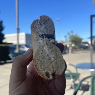 a hand holding a bagel
