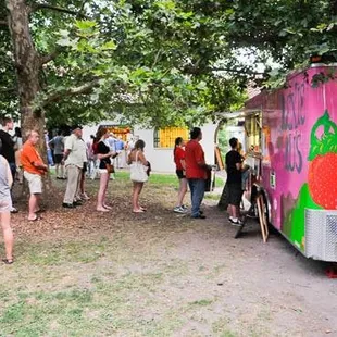 a group of people standing in front of a food truck