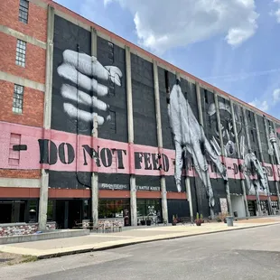 a brick building with a large mural of a fist