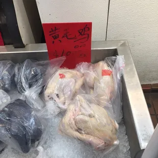 a display of raw chicken in plastic bags