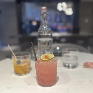 a table with a drink and two glasses