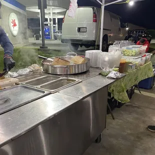 a man preparing food at a food stand