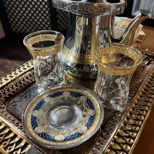 a silver tea pot and glasses