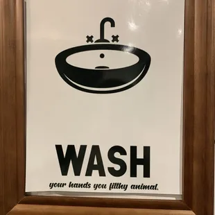 a bathroom sign with a sink