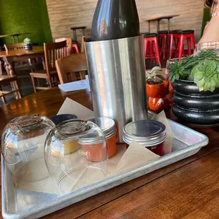 a tray of condiments and a bottle of wine