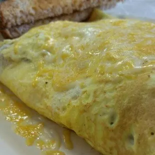 western omelet shredded cheese. includes ham, bacon, sausage, bell peppers, and tomatoes. served with toast or biscuits n gravy