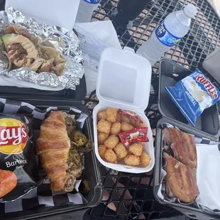 Boudin croissant, fried shrimp taco, tater tots, and cuban sandwhich served with chips
