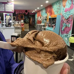 a person holding a cup of ice cream