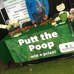 a man standing behind a table with a sign that says put the pop with grass