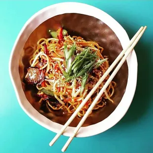 a bowl of noodles and chopsticks