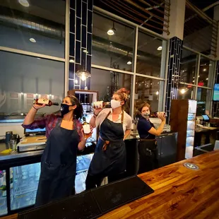 Ladies behind the bar, making and puring drinks for themselves