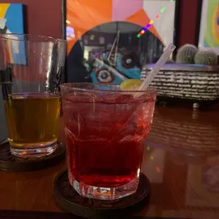 two glasses of cocktail on a bar
