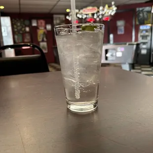 a glass of ice water with a straw