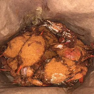 three crabs in a brown paper bag