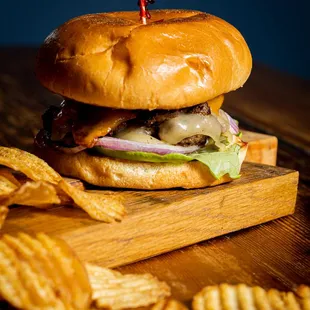 a hamburger and chips on a cutting board