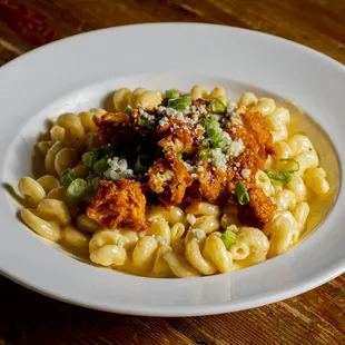 a plate of pasta with chicken and peas