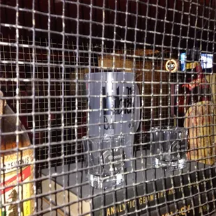 a bar with a clock behind a wire fence
