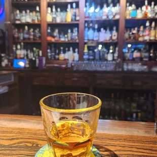 a glass of whiskey on a coaster