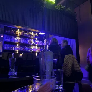 people sitting at a bar with drinks
