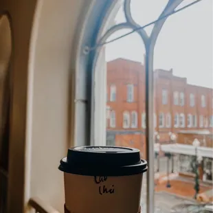 a cup of coffee in front of a window