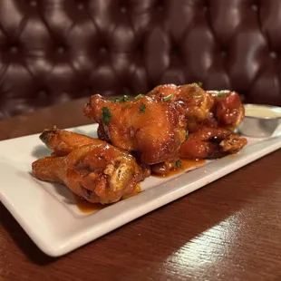a plate of chicken wings with sauce