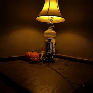 a table with a lamp and a pumpkin
