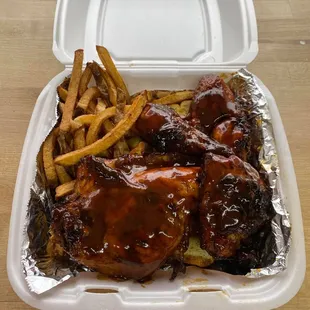 ribs and french fries in a styrofoam container
