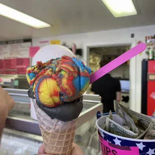 a hand holding a cone of ice cream