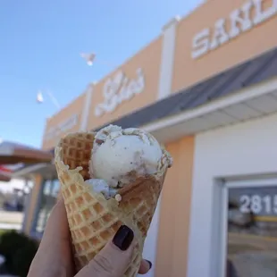 a hand holding an ice cream cone