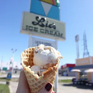 a hand holding a cone of ice cream