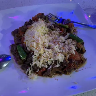 a plate of rice with meat and vegetables
