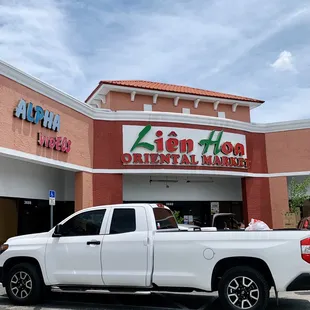 a white truck parked in front of the store