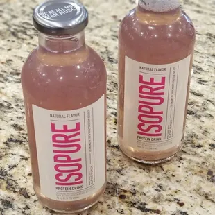 two bottles of liquid on a granite countertop