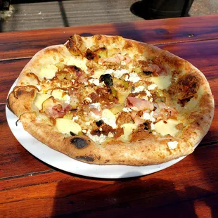 Outdoor dining with a bacon, goat cheese, leeks, and caramelized onions pie with fennel sausage added! So scrumptious!