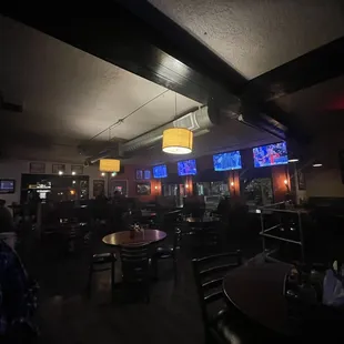 people sitting at tables and watching televisions