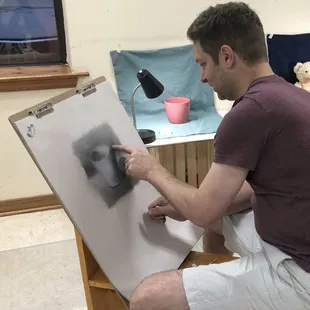Adult student working on a still life tone drawing.