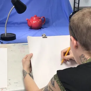 Adult student working on still life drawing.