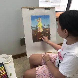 Children's art class student working on a pastel picture.