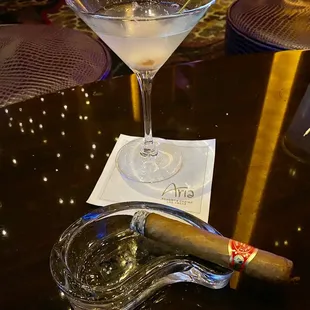 a glass of martini and a cigar