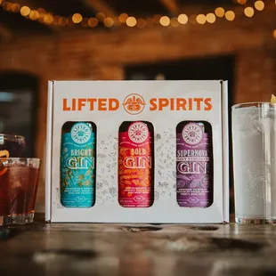 three bottles of gin and a glass of gin