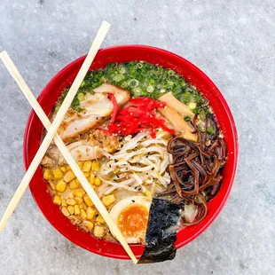 a bowl of ramen noodles with chopsticks